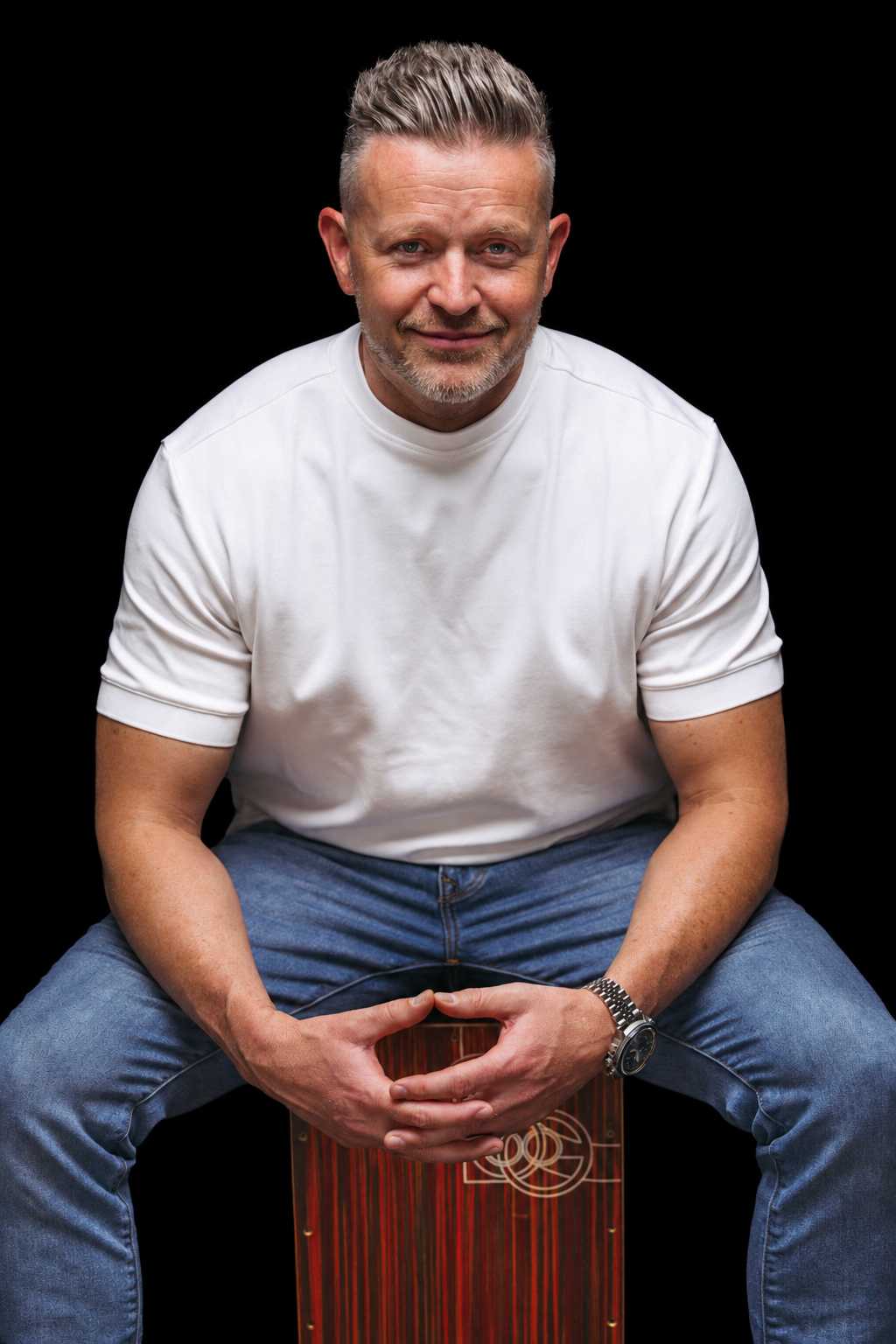 Portrait of Josh Turner seated in a white shirt against a black background.